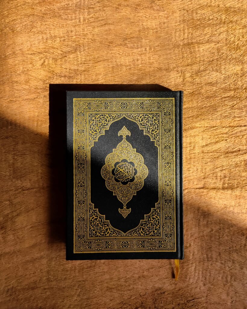 A beautifully decorated Quran resting on a rich brown wooden table, capturing spiritual essence.